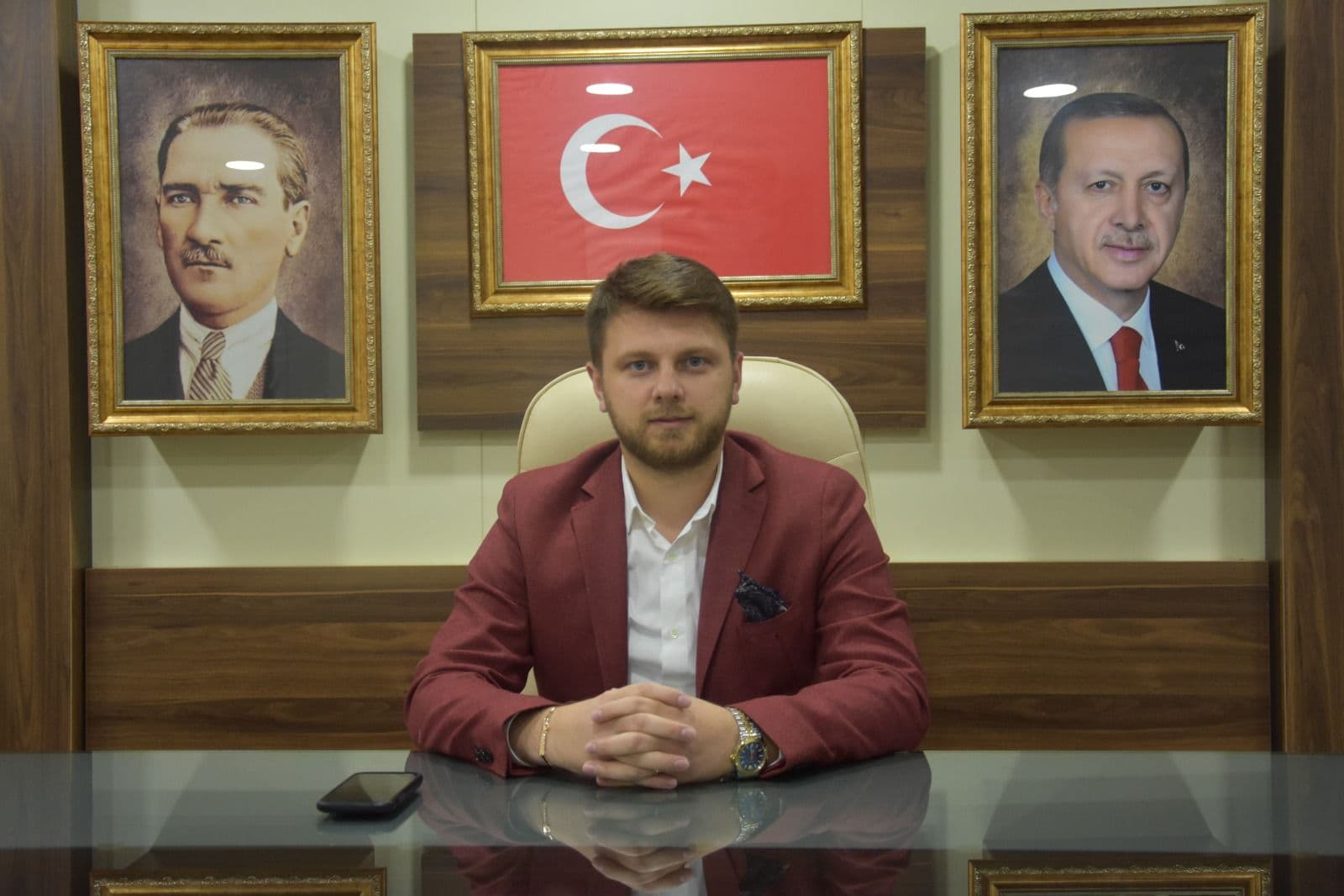 Ömer Yazıcıoğlu, Atatürk ve Cumhurbaşkanı portreleri ile Türk bayrağının asılı olduğu ofiste masasında