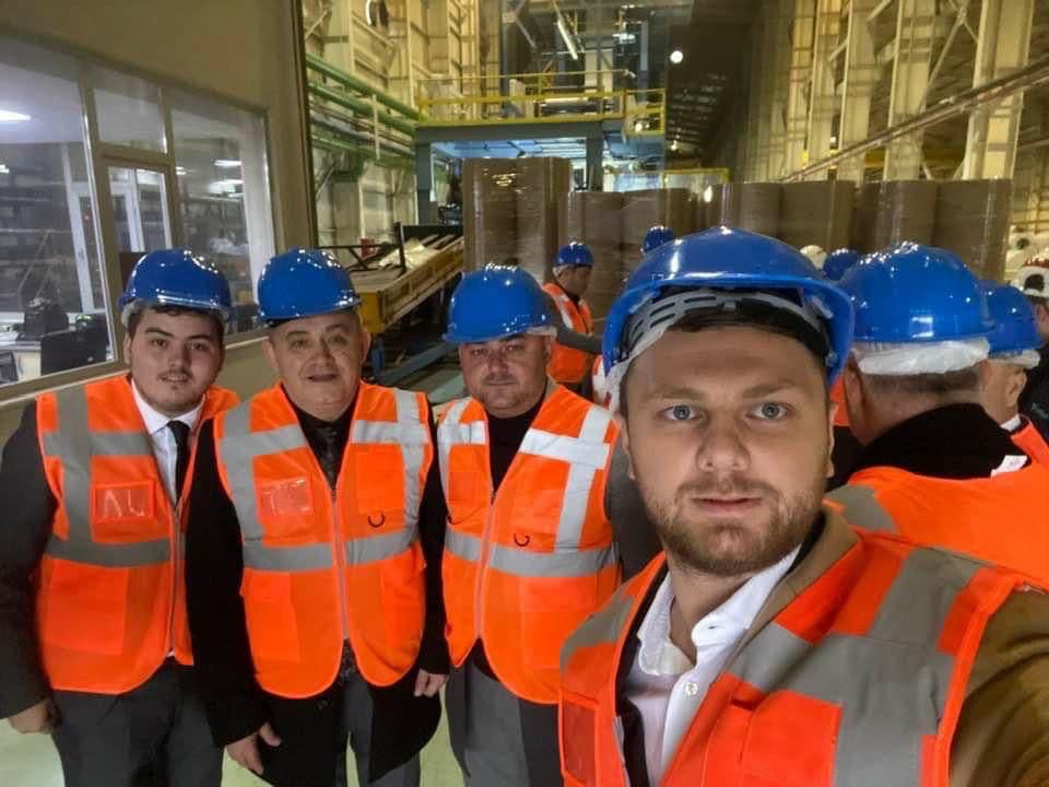 Ömer Yazıcıoğlu ve heyet, baret ve reflektörlü yelekle bir fabrika gezisinde