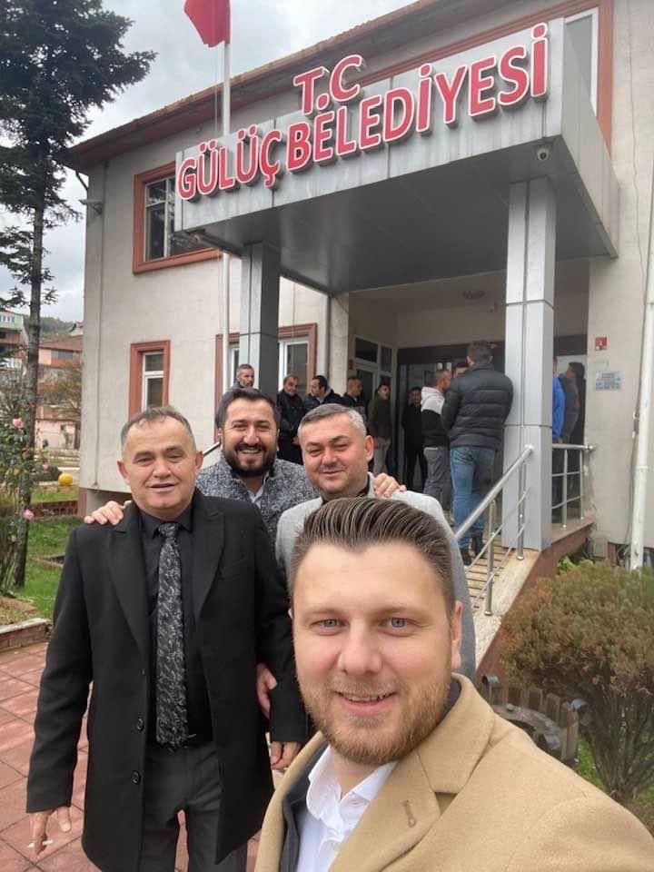Ömer Yazıcıoğlu ve üç kişi, bir kamu binasının önünde özçekim