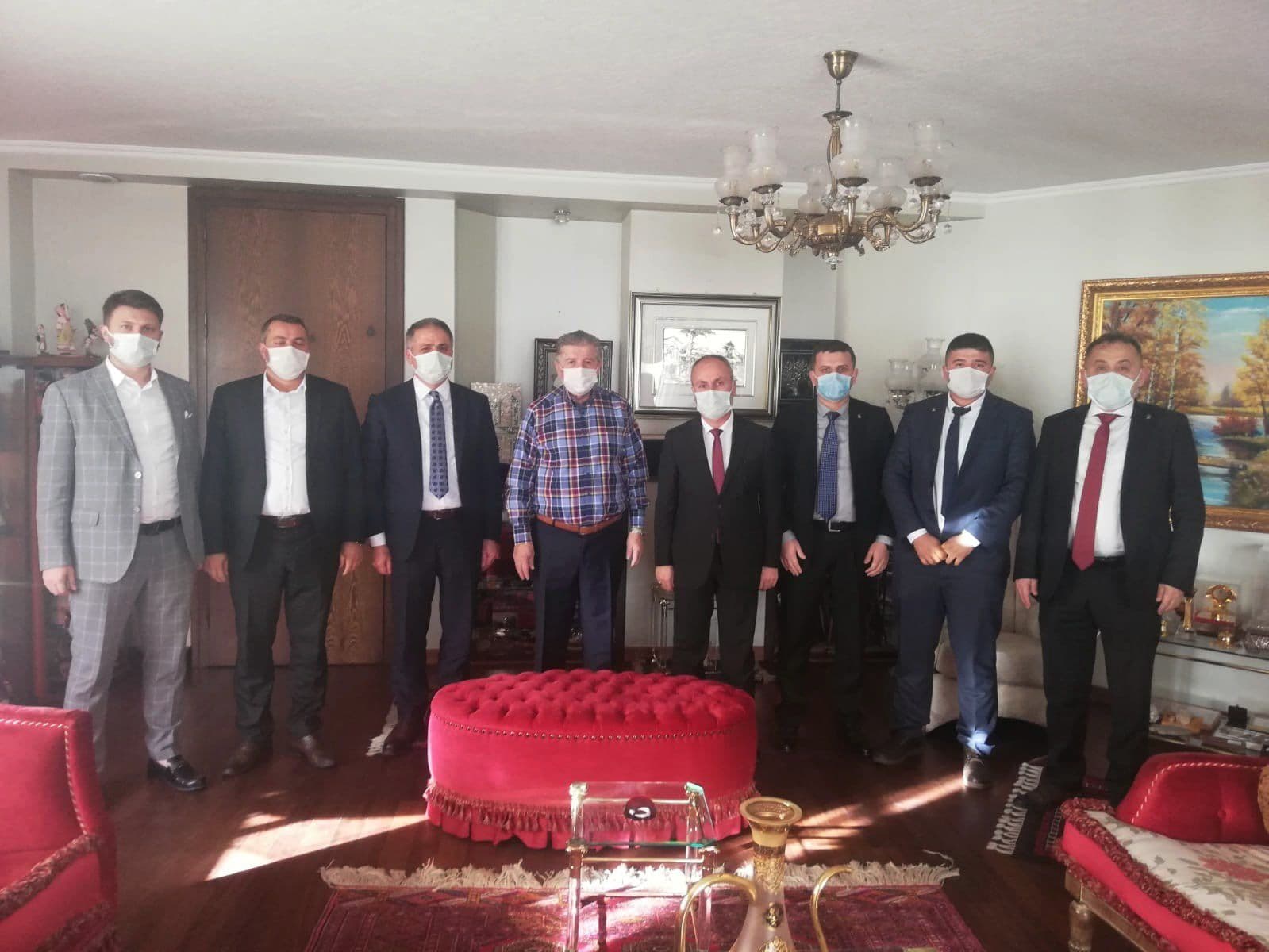 Maske takan sekiz kişilik heyetin bir konutta çekilmiş toplu fotoğrafı
