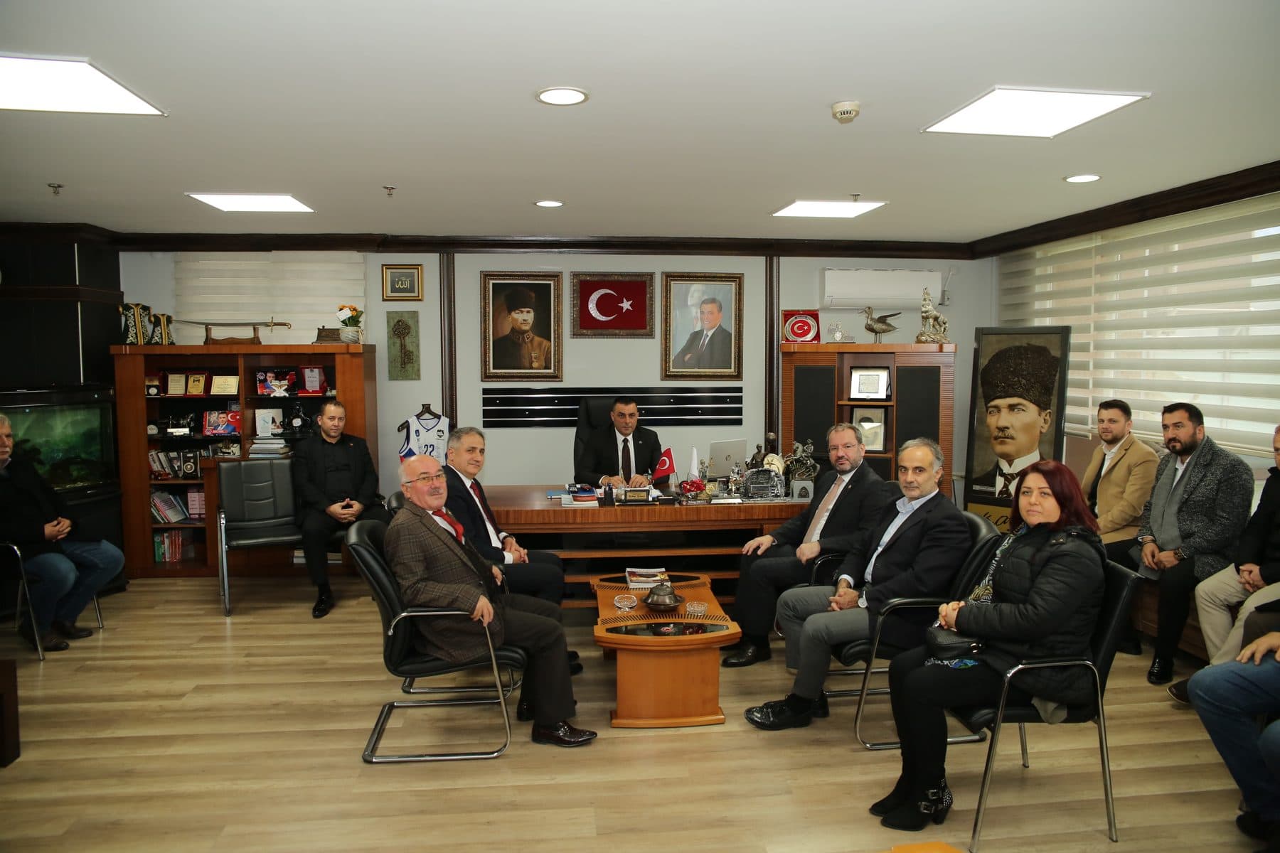 Bir dernek lokalinde masa etrafında toplanan yöneticiler ve konuklar