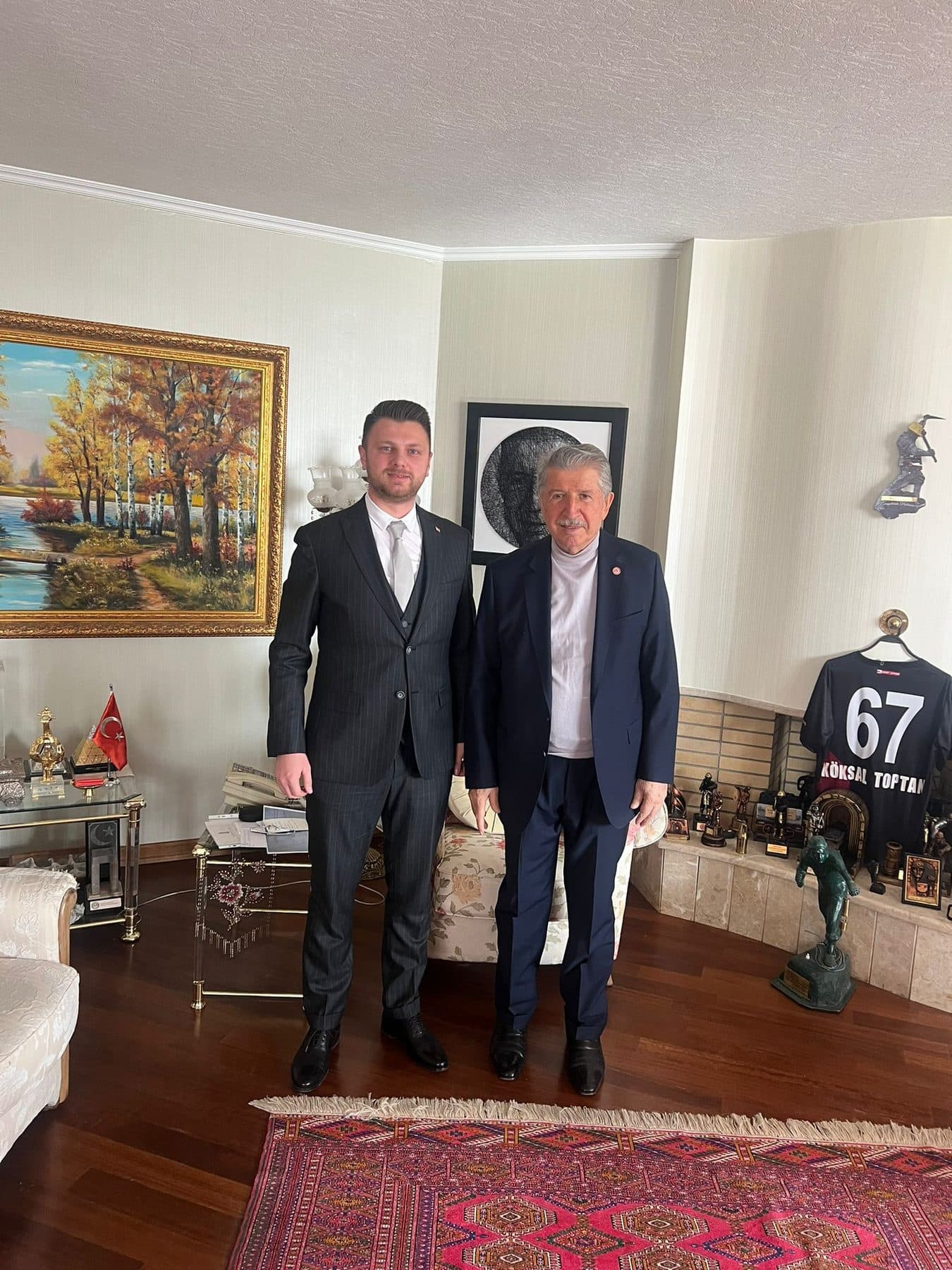 Ömer Yazıcıoğlu, duvarında manzara tablosu ve isimli bir spor forması bulunan konutta ev sahibiyle